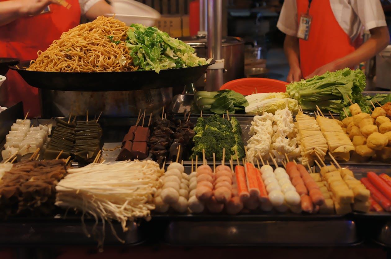 Asian street food vendor preparing food at night market stall